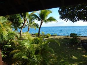 vistas a una playa con palmeras y al océano en A Pueu Village, en Pueu