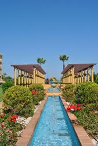 a water feature in a garden with two building w obiekcie Apartamento Deluxe Vistas Laterales al Mar w mieście Isla Canela