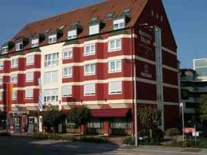 ein großes rotweißes Gebäude auf einer Straße in der Unterkunft Best Hotel ZELLER in Königsbrunn