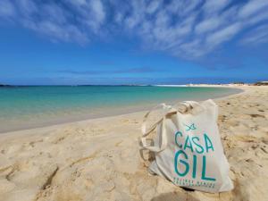 a white bag sitting on the sand on a beach at Casa Gil Corralejo San Valentin in Corralejo