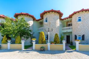 a home in the desert with trees in front of it at Apartments Alexandros in Polychrono
