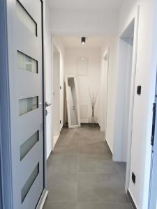 a hallway with white doors and a tile floor at Guesthouse Korkyra Sun in Korčula