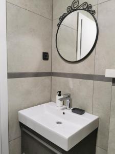 a bathroom with a white sink and a mirror at Guesthouse Korkyra Sun in Korčula