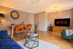 a living room with a blue couch and a tv at Tattenhoe House with Free Parking, Fast Wifi, Garden and Smart TV by Yoko Property in Milton Keynes