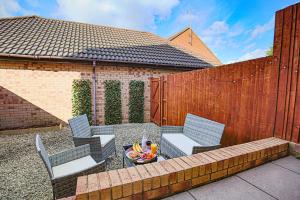 a patio with a table and chairs and a fence at Tattenhoe House with Free Parking, Fast Wifi, Garden and Smart TV by Yoko Property in Milton Keynes