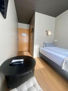 um quarto com uma cama e uma mesa preta em North West Restaurant & Guesthouse em Víðigerði