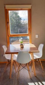 uma mesa e cadeiras num quarto com uma janela em Casa Bosque em San Carlos de Bariloche