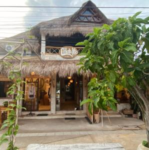 a store with a thatched building with a tree in front at L hotelito in Tulum