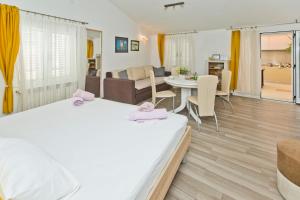 una camera con due letti e un soggiorno di Apartments Jure a Hvar