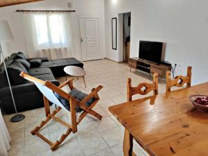 a living room with a couch and a table at Cozy cottage with garden and olive grove of 5 acr in Mavráta