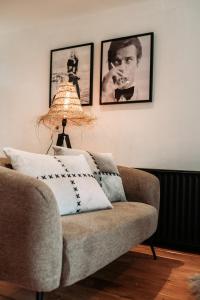 un soggiorno con divano e immagini appese al muro di Het Houten Huisje 84 Luxe vakantiewoning Zuid Limburg a Simpelveld