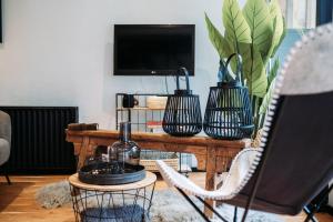 a living room with a table with two chairs and a tv at Het Houten Huisje 84 Luxe vakantiewoning Zuid Limburg in Simpelveld