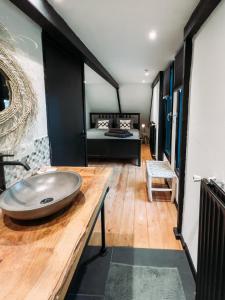 een badkamer met een grote wastafel en een bed bij Het Houten Huisje 84 Luxe vakantiewoning Zuid Limburg in Simpelveld