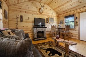 Cabaña de madera con sala de estar con chimenea en River's Sky View Lodge en Fredericksburg