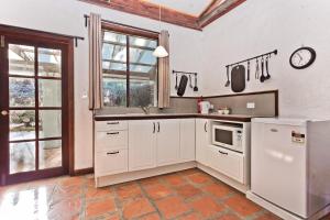 a kitchen with white cabinets and a microwave at Lavenderpatch in Mundaring