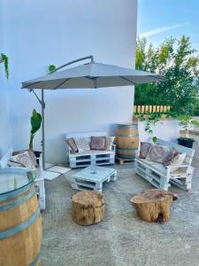 un patio con mesa, sillas y sombrilla en L'ANTICA PIETRA Casa Vacanza Salento, en Poggiardo