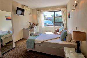 una camera d'albergo con letto e finestra di Hotel Thule a Windhoek