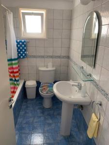 a bathroom with a sink and a toilet and a mirror at Gorgeous SeaView house in Pissouri