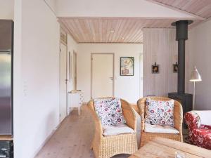 un soggiorno con 2 sedie e una stufa a legna di 6 person holiday home in Dronningm lle a Gilleleje