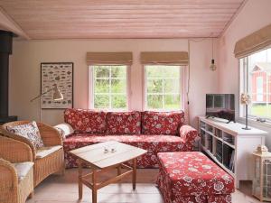 ジルレジェにある6 person holiday home in Dronningm lleのリビングルーム(赤いソファ、テーブル付)