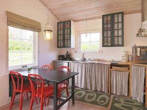 una cocina con mesa y algunas sillas rojas en 6 person holiday home in Dronningm lle, en Gilleleje