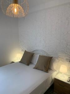a white bed with two pillows and a chandelier at Home SEA&DREAMS OldTown III in Calpe