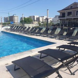 eine Reihe von Liegestühlen neben einem Swimmingpool in der Unterkunft Studiou Andu Nord 10 by Alezzi in Năvodari
