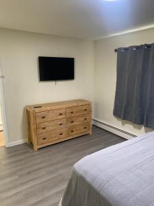 1 dormitorio con TV de pantalla plana en la pared en Yankee Clipper Resort Motel, en Wildwood Crest