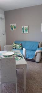 salon z niebieską kanapą i stołem w obiekcie SOPHIA Appartament w mieście Trappeto