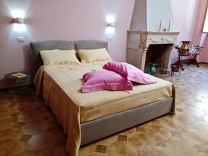 1 cama con almohadas rosas en una habitación con chimenea en Ca' di Renzo en Macchiagodena