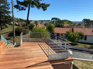 a wooden deck with a metal railing on it at Anglet, un p'tit coin de paradis in Anglet