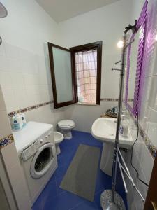 a bathroom with a toilet sink and a washing machine at Villa Barraco Paradise in San Vito lo Capo