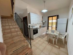 a kitchen with a staircase and a table and a kitchen with a tableablish at Villa Barraco Paradise in San Vito lo Capo +23 photos