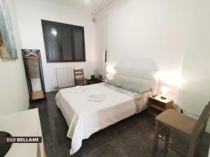 um quarto com uma grande cama branca e uma cadeira em BELLAMI' ECONOMI em Tuglie