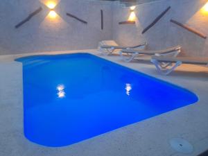 a blue swimming pool in a room with lights at Las Aguardas in Belmonte