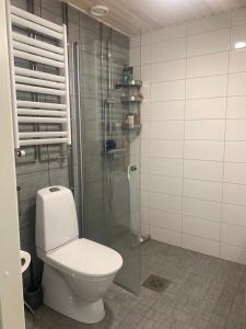 a bathroom with a toilet and a glass shower at Modern one bedroom apartment nearby Airport in Vantaa