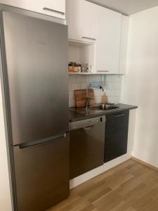 a kitchen with a stainless steel refrigerator and a sink at Modern one bedroom apartment nearby Airport in Vantaa