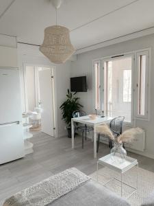 a white living room with a table and a refrigerator at Modern one bedroom Apartment with Sauna near Airport in Vantaa