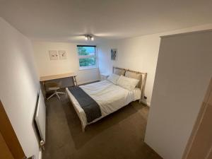 a small bedroom with a bed and a window at Spacious 2-Bedroom Flat Near Surbiton Station in Surbiton