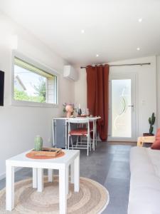 een woonkamer met een witte bank en een tafel bij L'HACIENDA CHAMPENOISE in Châlons-en-Champagne