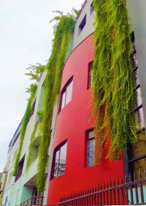 un edificio rojo con plantas a su lado en Eastern House - Peaceful Living at Diplomatic Zone, en Dhaka