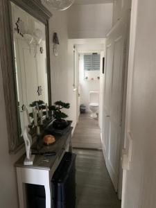 a hallway of a bathroom with a sink and a mirror at Appartement Au Quai 1921 in Besançon +3 photos