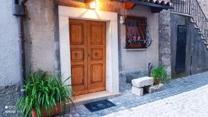 una porta di legno sul lato di un edificio con piante di B&B Valle Cicala a Pescasseroli