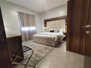 a bedroom with a large bed with a white bedspread at العبير شقة فندقية in King Abdullah Economic City