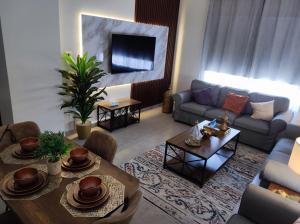 a living room with a couch and a table at العبير شقة فندقية in King Abdullah Economic City