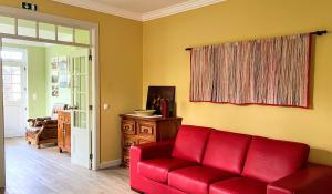 a red couch in a living room with a window at Casa da Japoneira in Horta