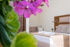 a room with a bed and a purple flower at Blue Green Bay in Panormos Skopelos