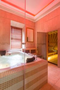 een grote badkamer met een bad en een raam bij Hotel Golden Palace in Sint-Petersburg