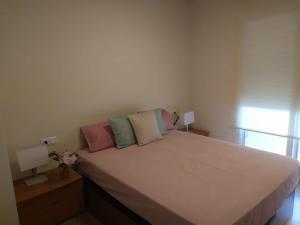 a bedroom with a large white bed with colorful pillows at Àtic Montsià - Àtic amb chill-out in Amposta
