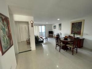 sala de estar y comedor con mesa y sillas en Apartamentos En Edificio Portofino ICDI en Cartagena de Indias